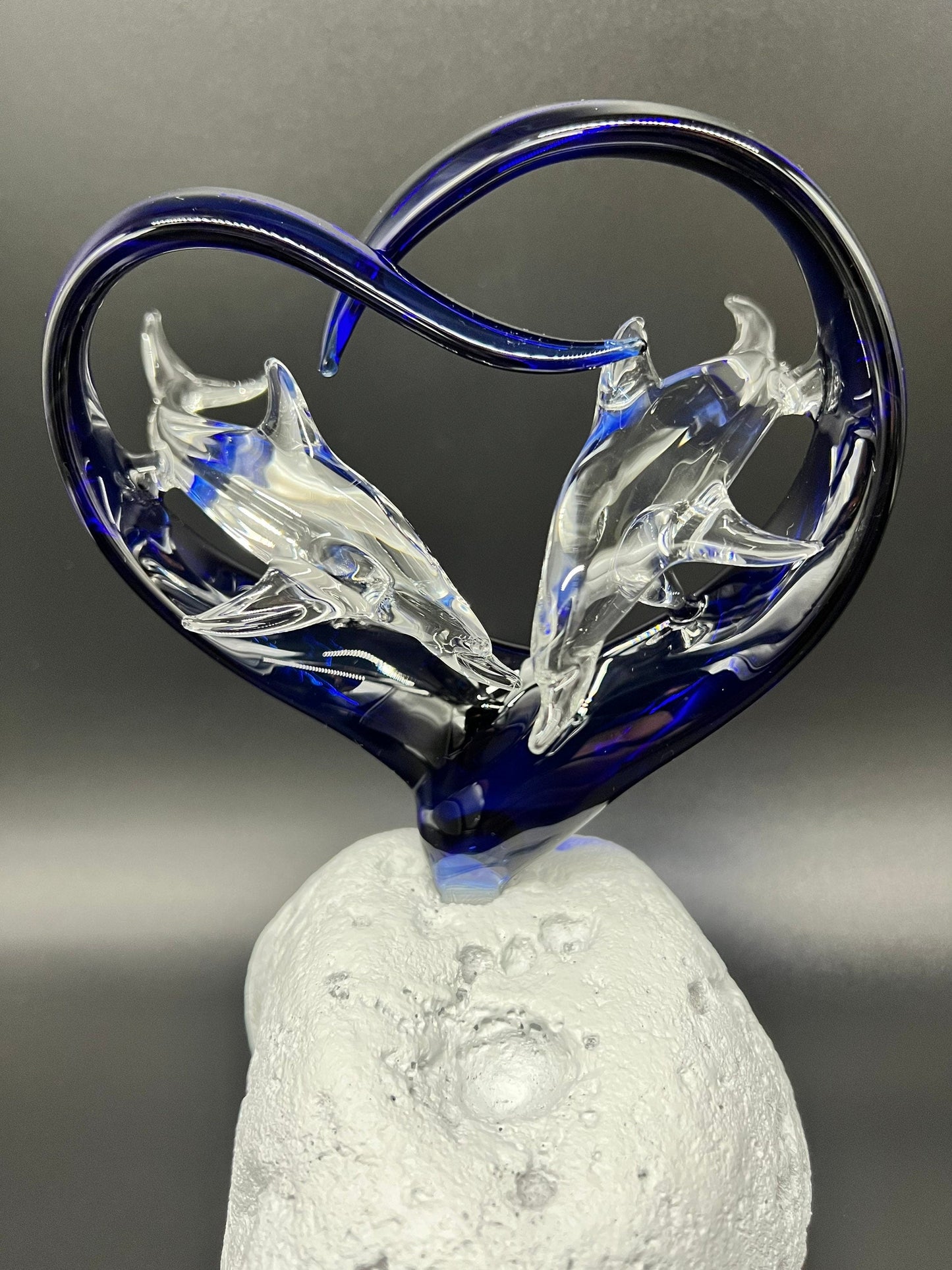 Two dolphins in a cobalt heart glass sculpture